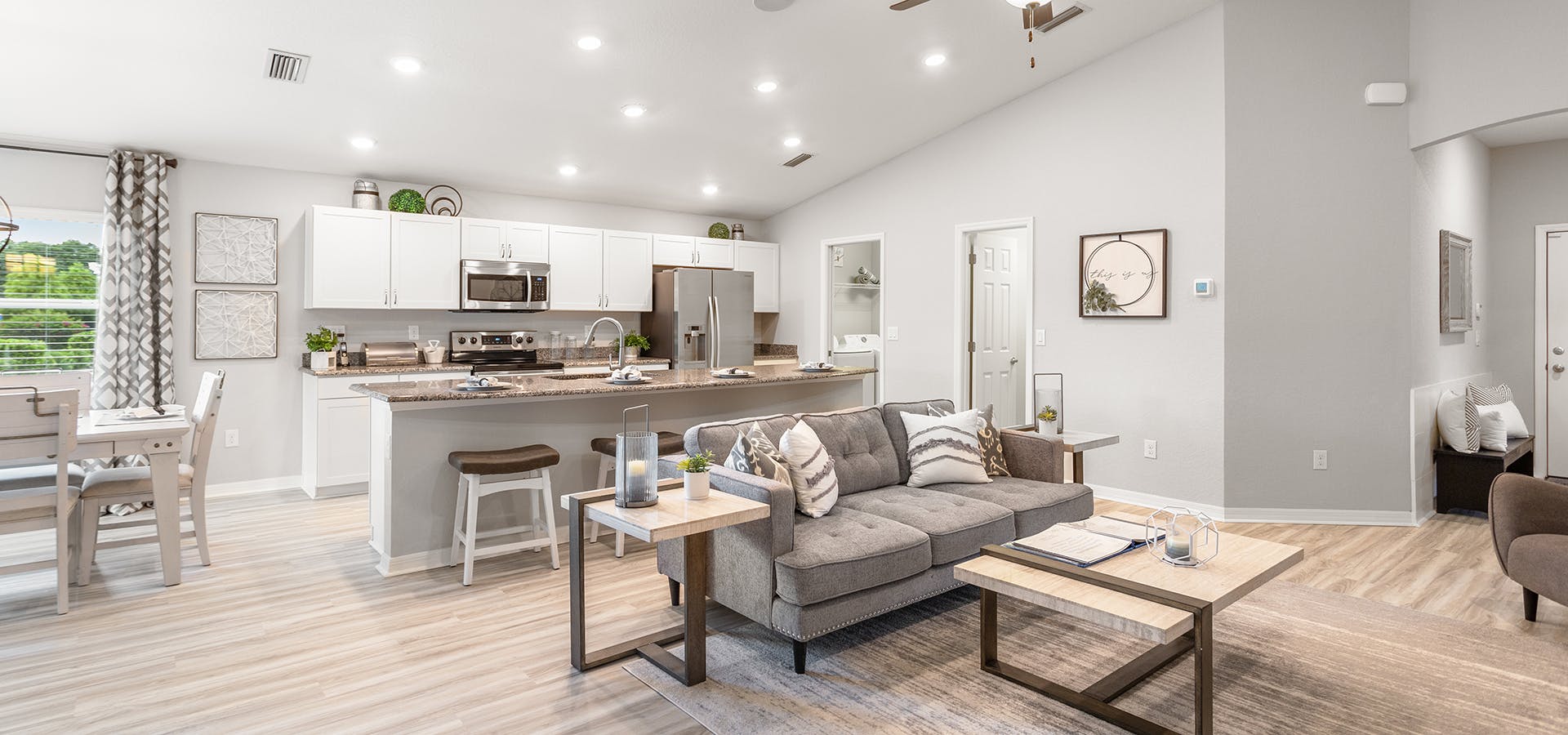 Bright and open living area with white cabinets and light colored LVP flooring