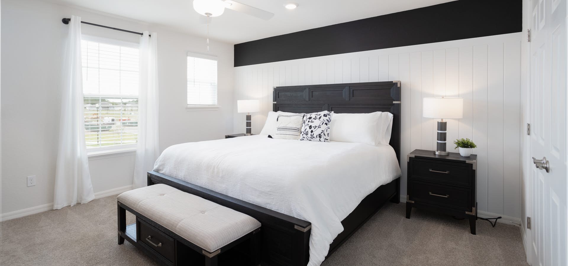 Black and white master bedroom suite with beadboard accent wall