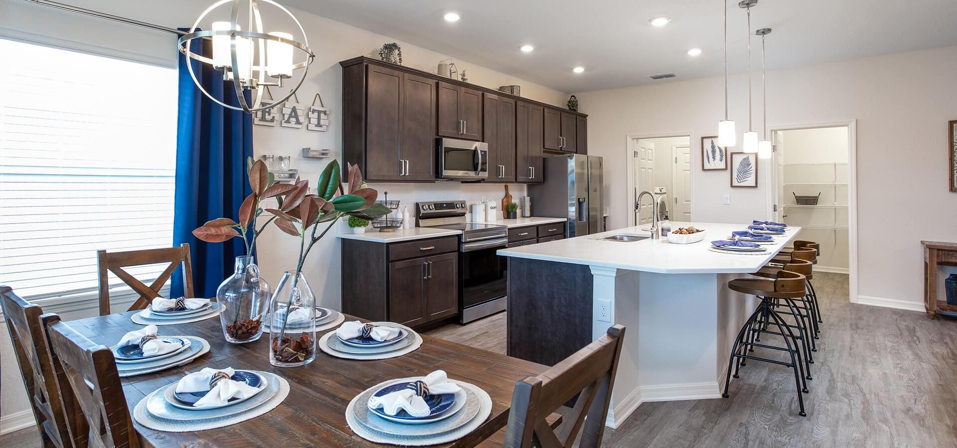 Kitchen and dining in the Shelby model at Astonia by Highland Homes