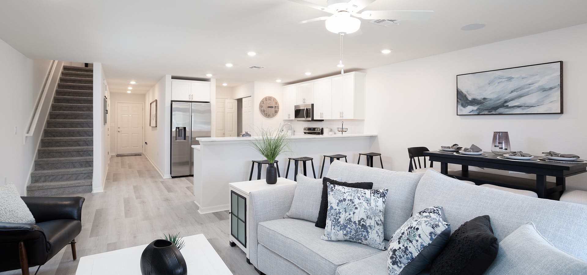 Open living area and kitchen with white cabinets and breakfast bar