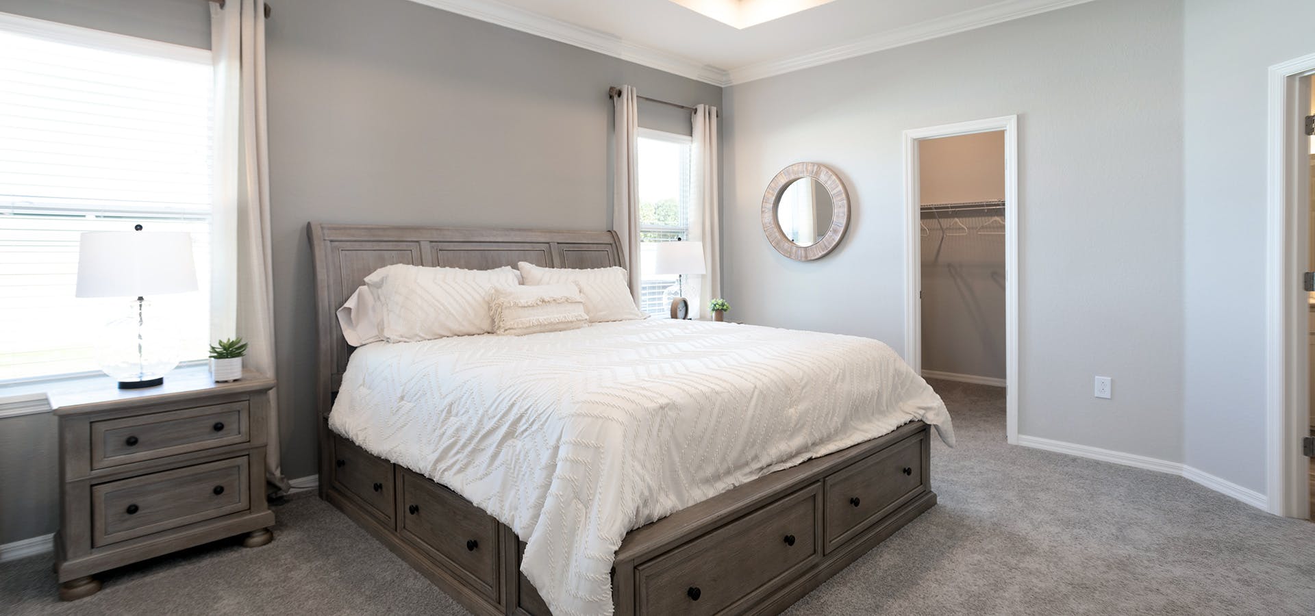 This spacious owner's suite combines wood furniture with shabby chic linens