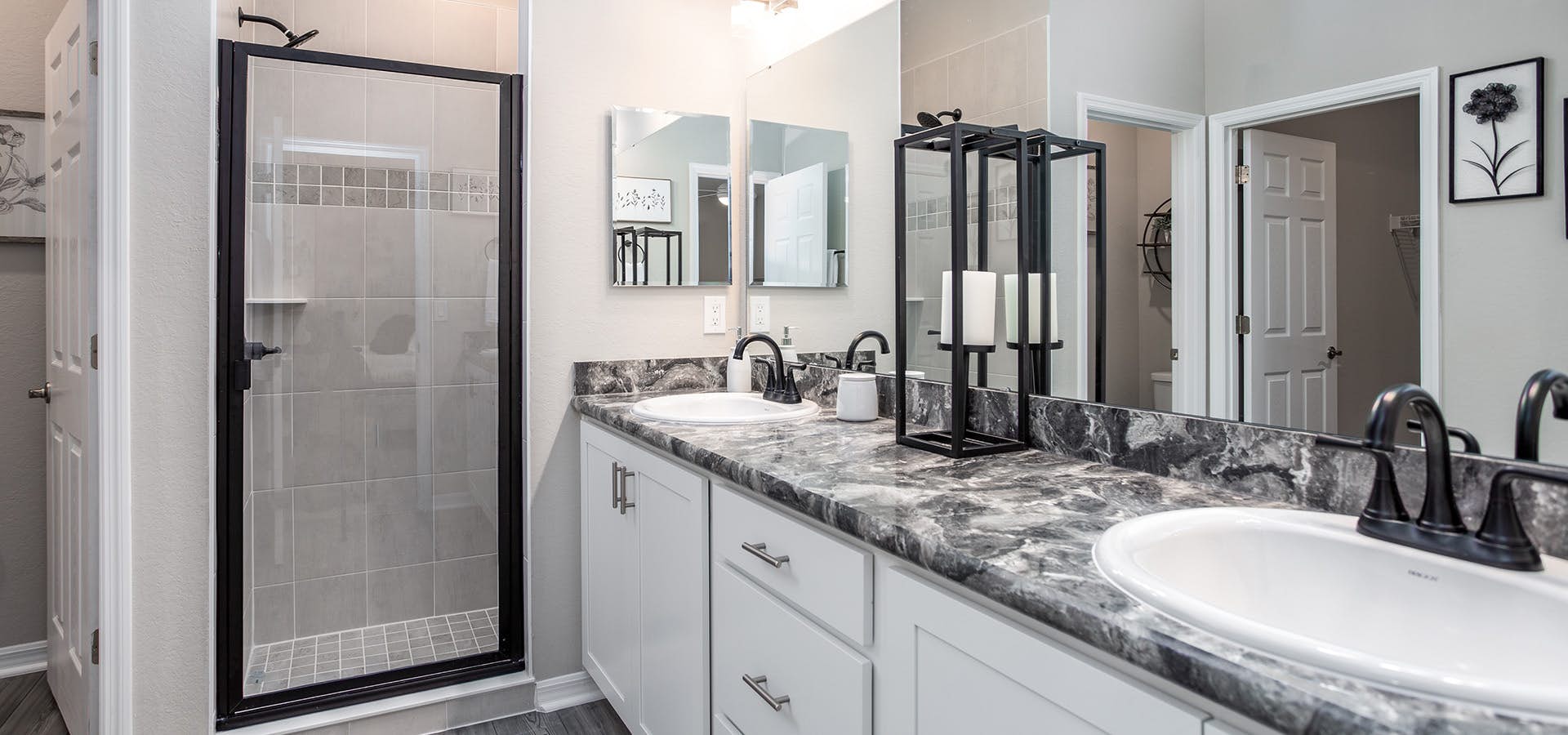 Large en-suite bathroom with white cabinets and dark fixtures