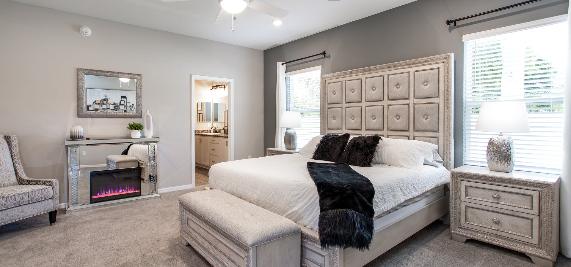 Big bedroom with a fireplace and a large, lushly appointed bed