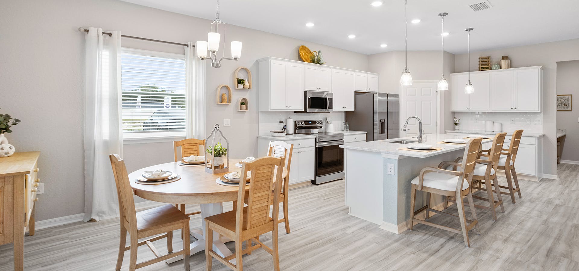 Sunny kitchen with white cabinets and quartz counters in the new Falls of Ocala model home
