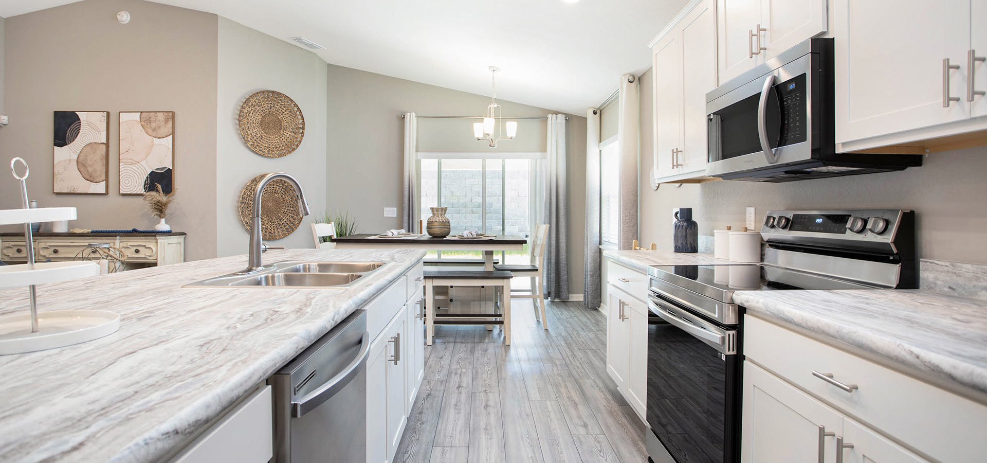 Warm and welcoming kitchen with white cabinets, rustic wood floors, and adjacent dining area.
