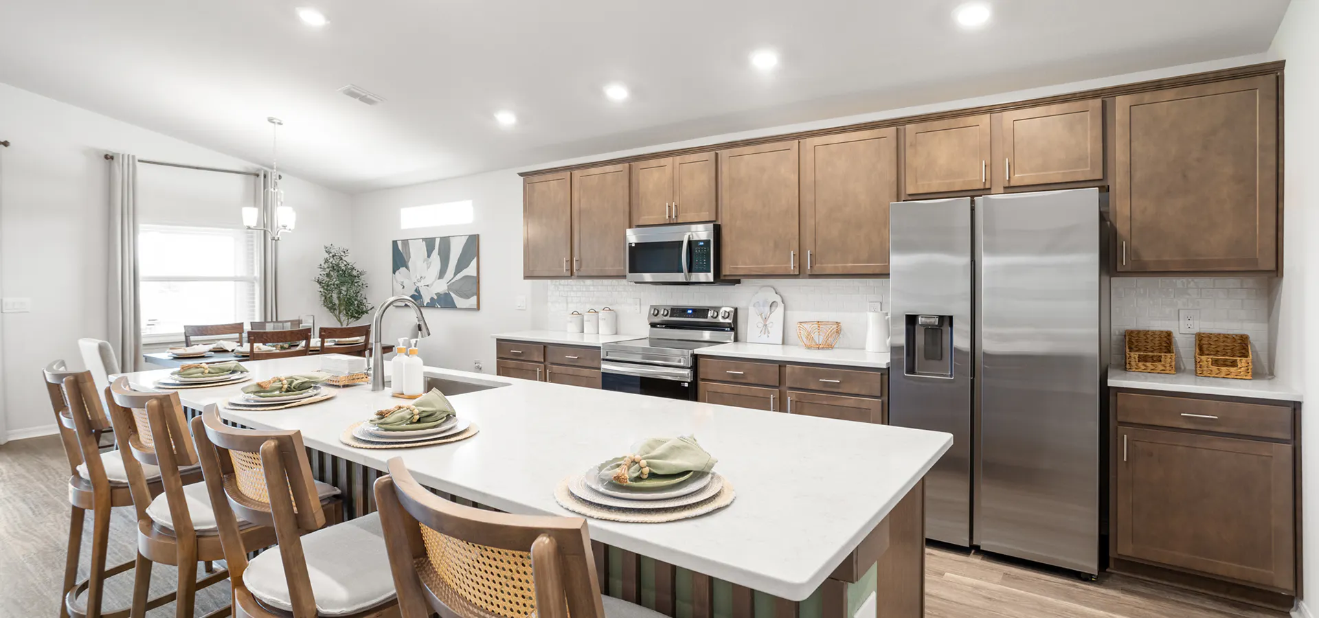 Kitchen with wood cabinets and quartz counters in a brand-new Lakeland model home