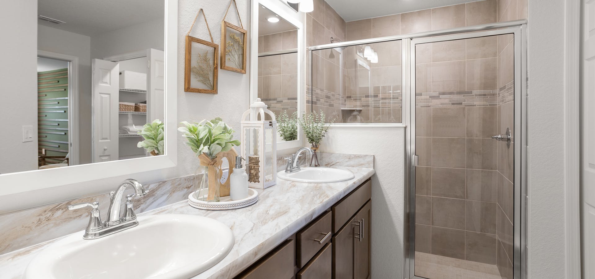 En-suite owner's bath in a Lakeland new home, with dual vanities and a large tiled shower