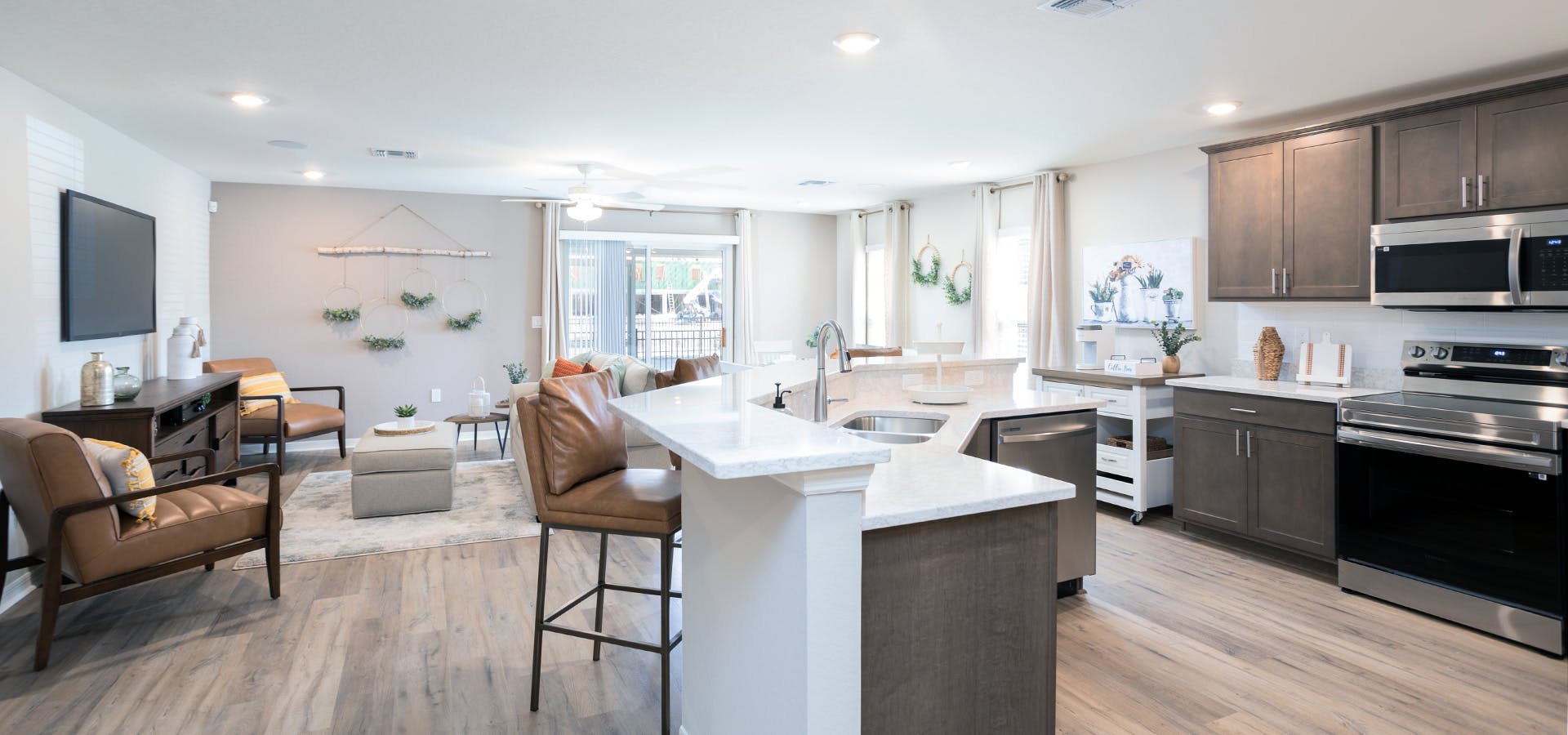 Open kitchen and living area with warm natural woods and leather furntiure