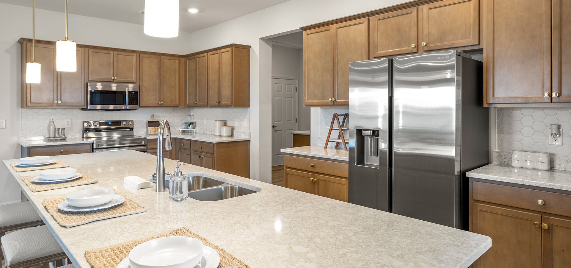 Large kitchen with oversized island, warm wood cabinets, and granite countertops