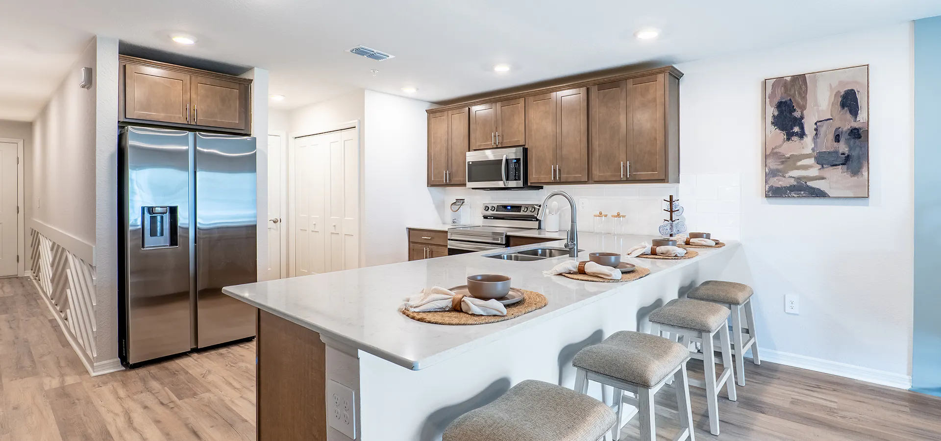 A new townhome in St. Cloud with wood cabinets, quartz counters, and a large bar