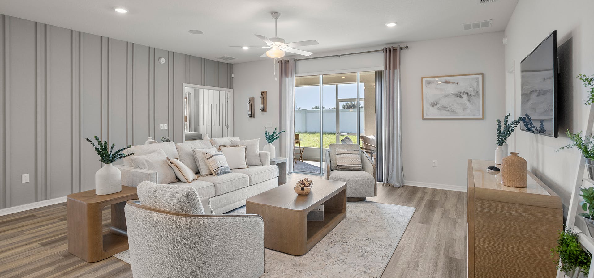 Gathering room with LVP flooring, neutral furniture, and a warm grey accent wall