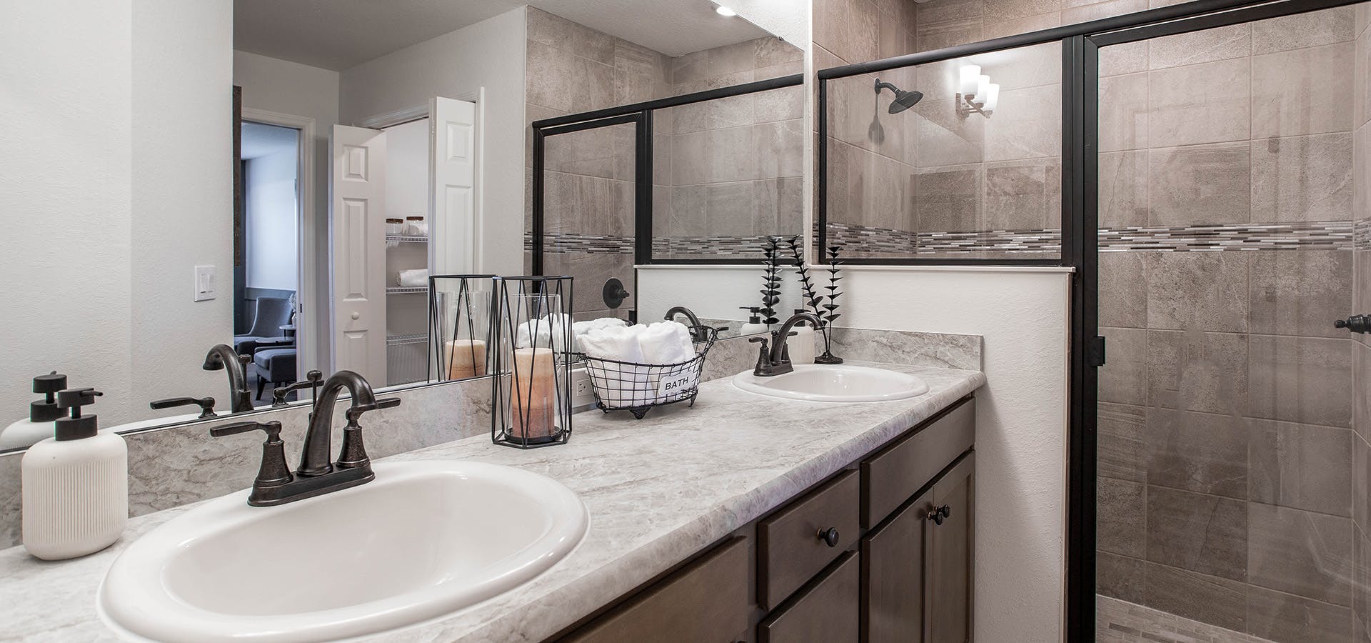 Owner's bath with dual vanities, a large tiled shower, and oil rubbed bronze plumbing fixtures