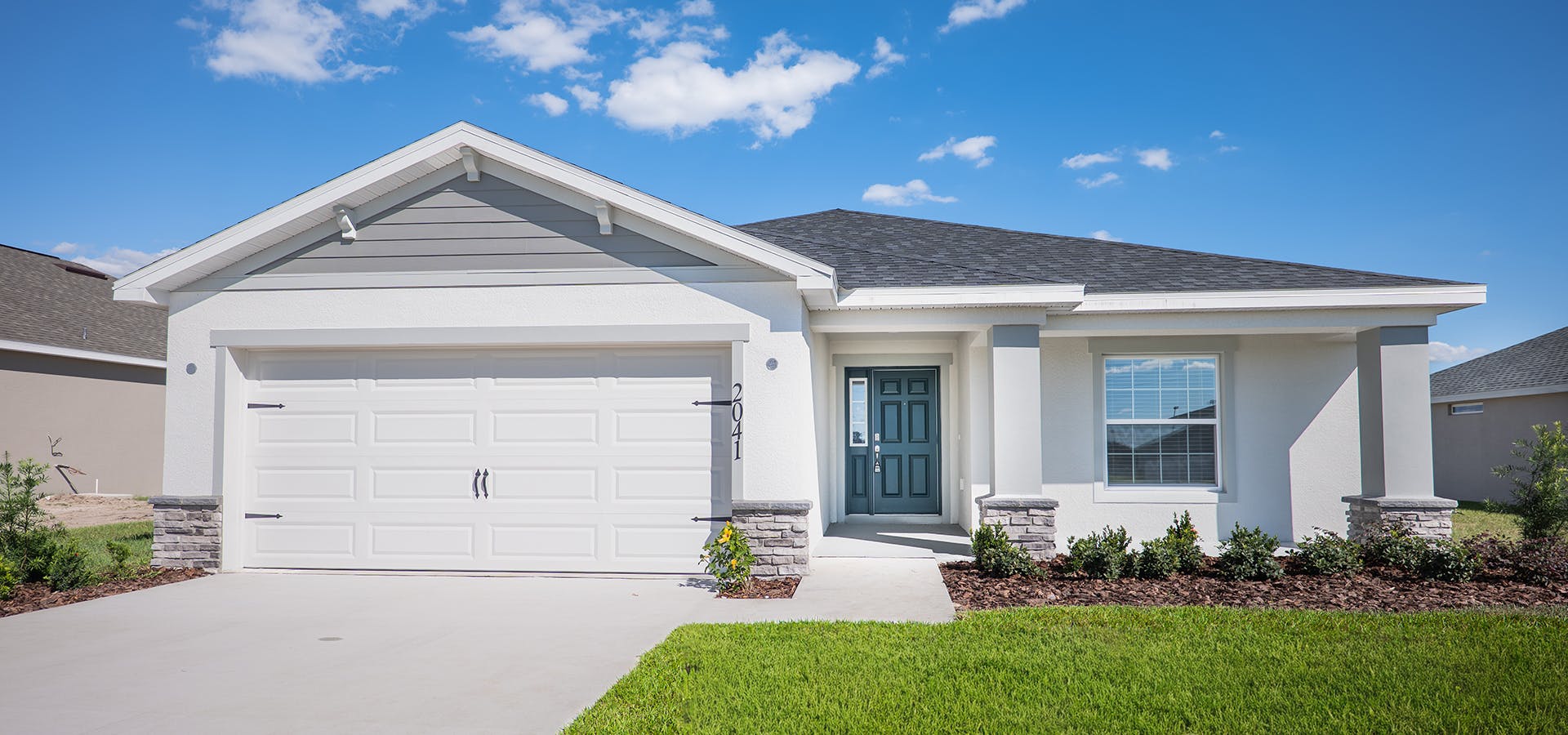 Exterior of the Raychel by Highland Homes, featuring a front porch, stone accents, and blue front door.