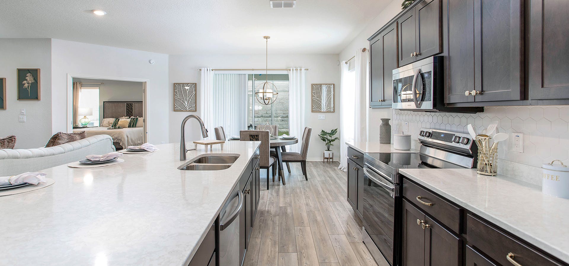 Kitchen with wood cabinets and floors and light colored quartz countertops