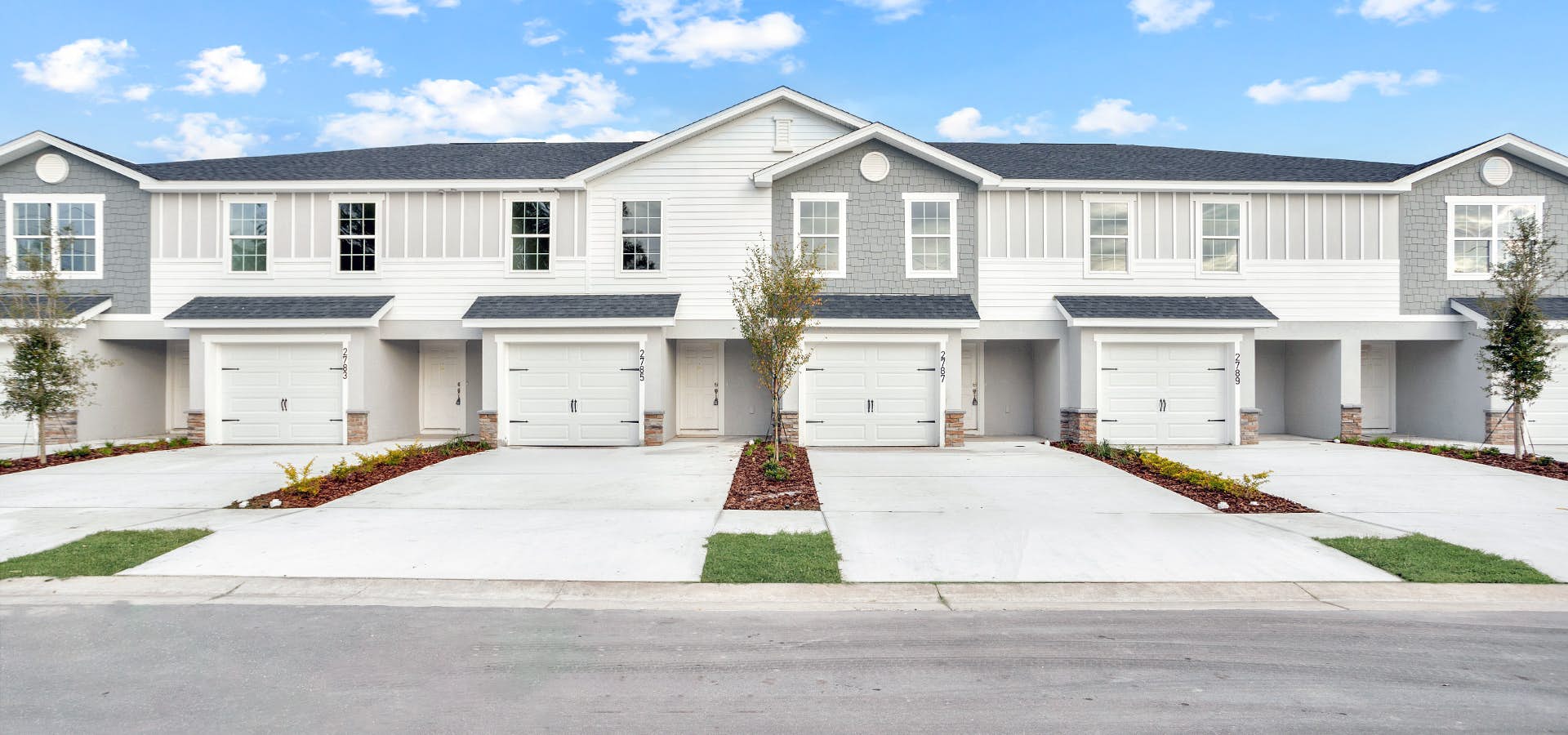 Townhomes in Plant City, FL with stone and trim details and 2-car driveway
