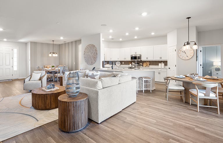 Open living area in the Westin II by Highland Homes in Tampa, decorated with mixed woods and light colors.