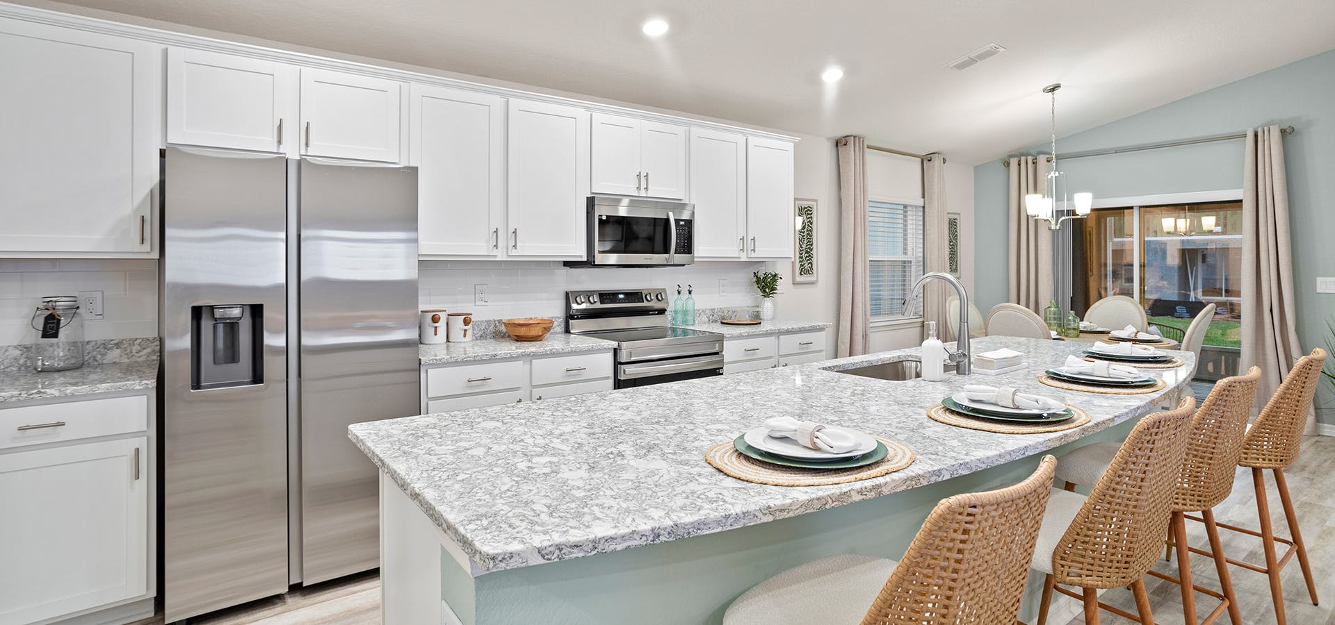 A bright, open kitchen with white cabinets and a large island, in a Winter Haven, Florida, new construction home.