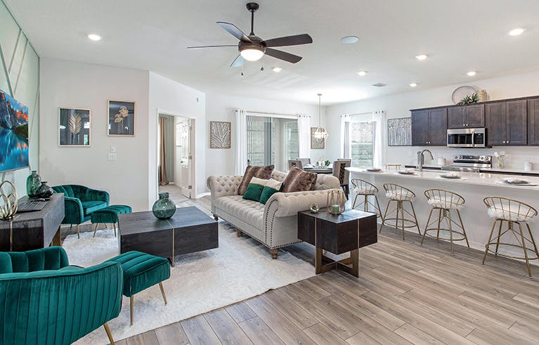 Spacious gathering room with wood finishes and glam furniture in the Shelby by Highland Homes.