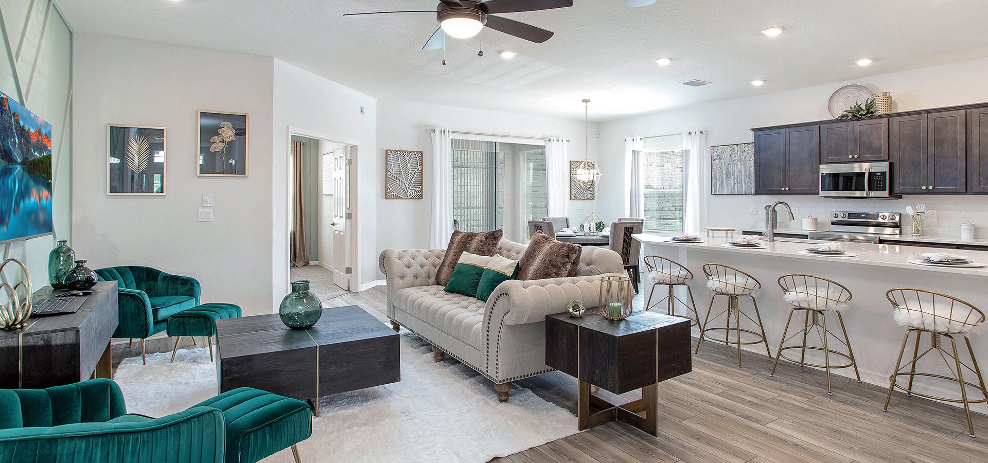 Spacious gathering room with wood finishes and glam furniture in the Shelby by Highland Homes.