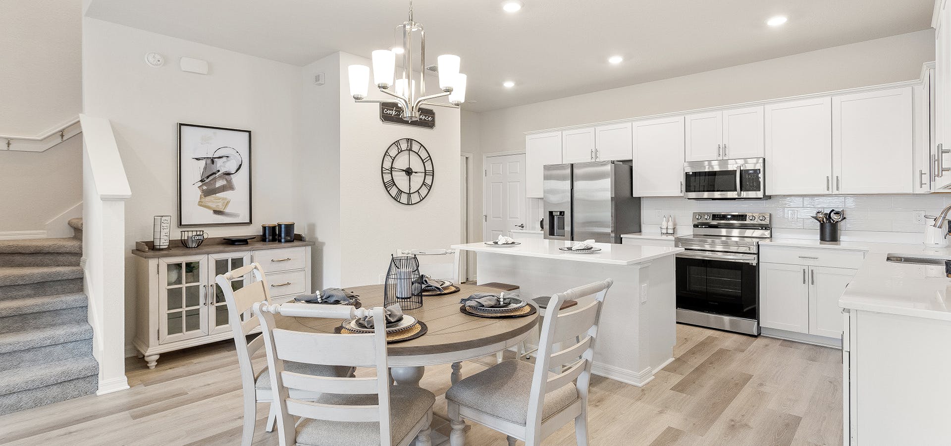A St. Cloud, Florida, townhome kitchen with white cabinets, wood floors, and eat-in space.