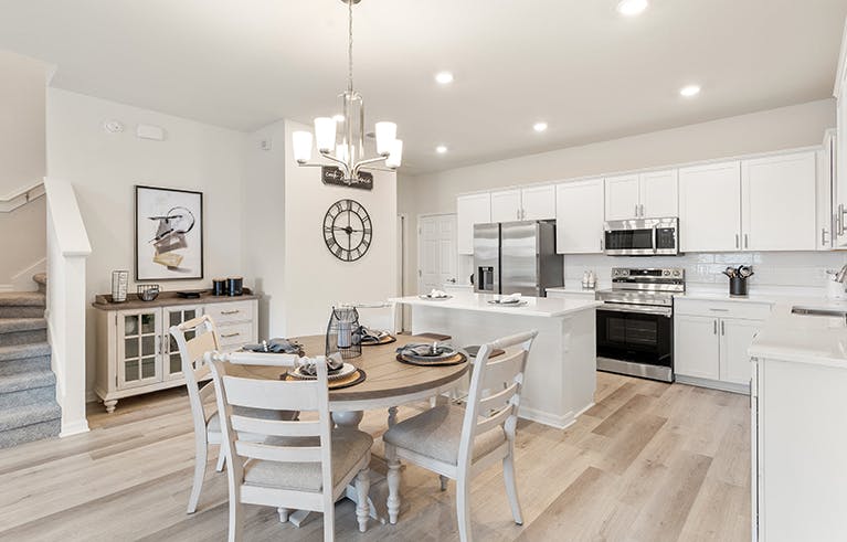 A St. Cloud, Florida, townhome kitchen with white cabinets, wood floors, and eat-in space.