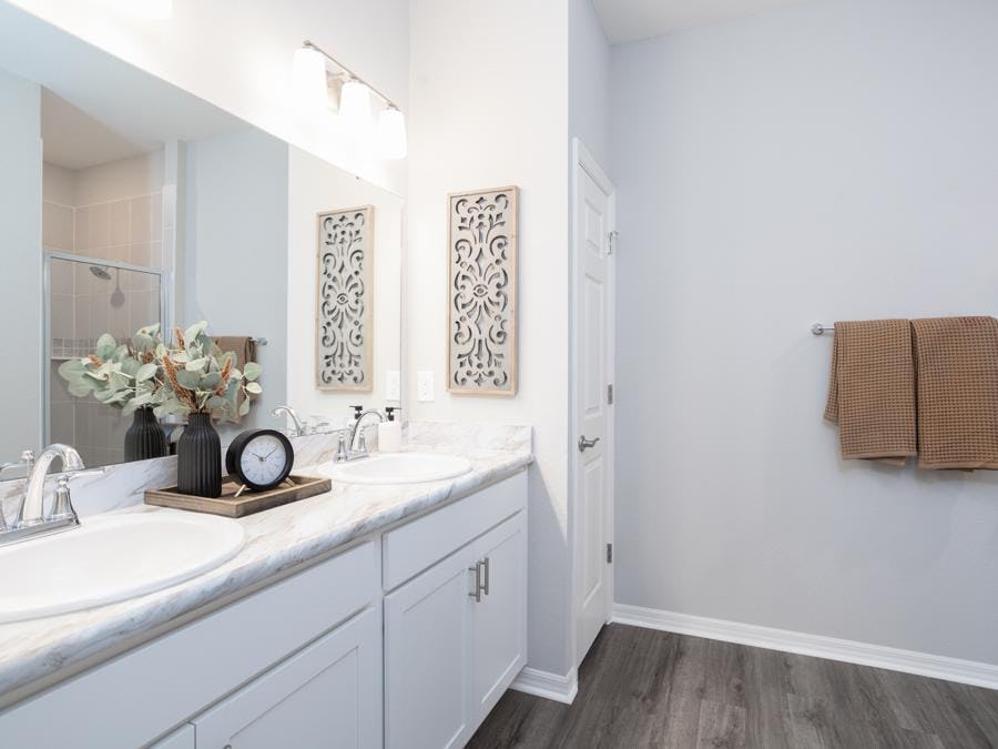 The Shelby model home in Auburndale, FL showcases a spacious en-suite owner's bath with white cabinets and a tiled shower.