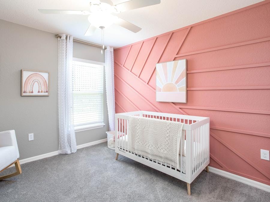 Girls nursery with bold coral wall color inspired by 2024 color trends