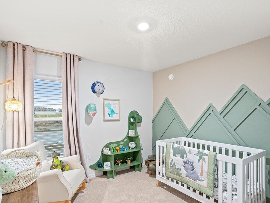 Nursery with mountain accent wall and dinosaur theme