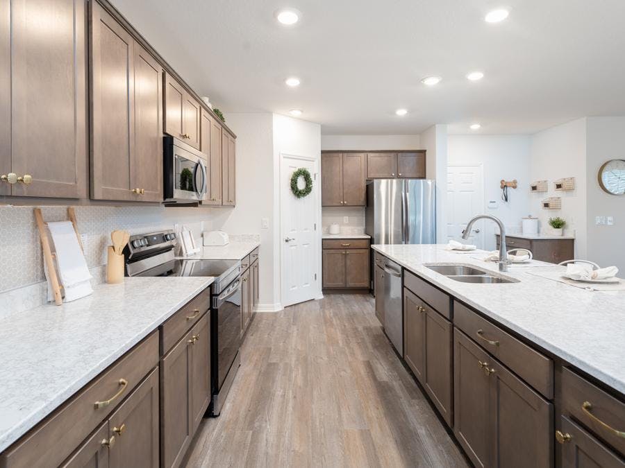 Soft-close wood cabinets and Cambria quartz countertops complete the kitchen in this Riverview model home